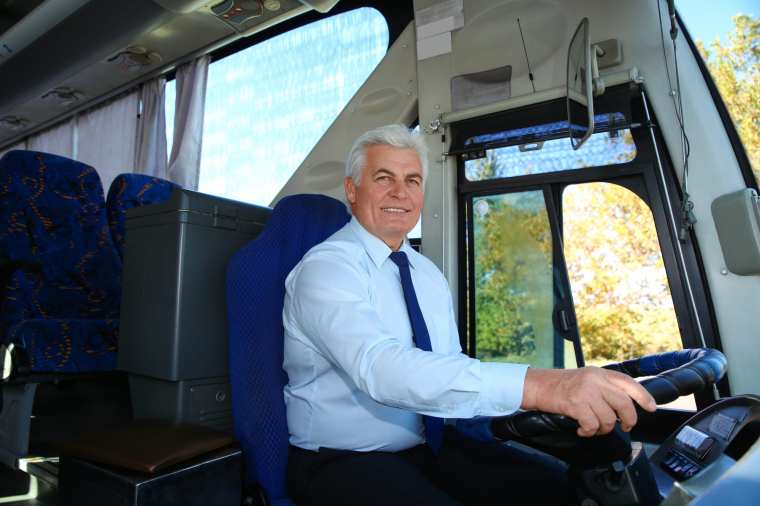 Professional bus driver at steering wheel. Passenger transportation