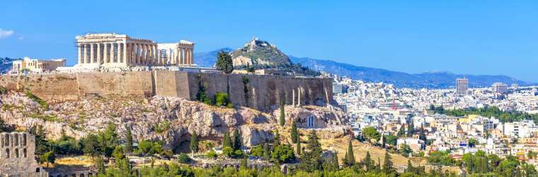 Panoramic view of Athens, Greece. Famous Acropolis hill rises above cityscape. It is top landmark of Athens. Landscape of old Athens city with Ancient Greek ruins. Skyline of Athens in summer.